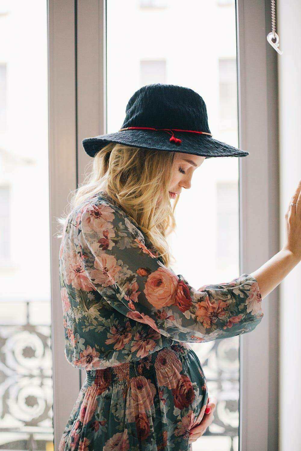 a pregnant young woman dressed fashionably